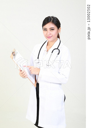 Female doctor holding clipboard pointing looking forward  13002502
