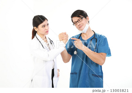 Male and female doctor in funny pose of arm wrestling  13003821