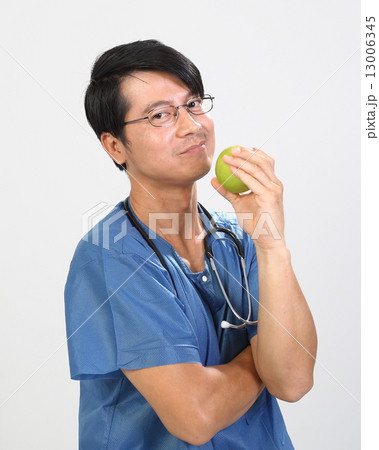 Male doctor in ot unifor with an apple Male doctor in ot unifor with an apple 13006345