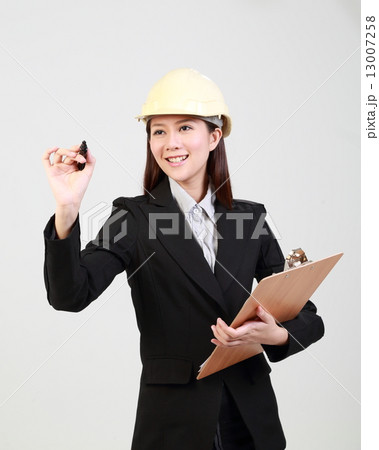 female with crash helmet holding clipboard and writing with pen female with crash helmet holding clipboard and writing with pen 13007258