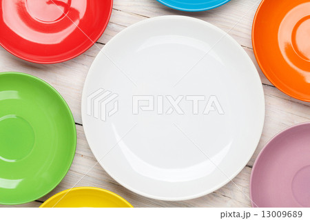 Colorful plates over wooden table 13009689