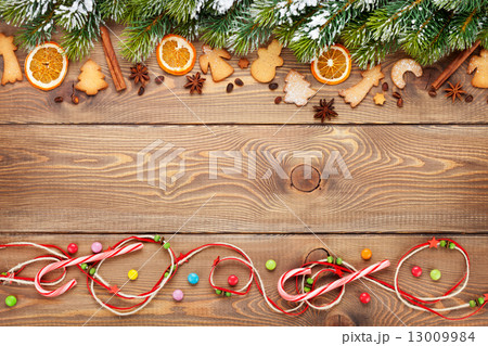 Christmas wooden background with snow fir tree, spices, gingerbr Christmas wooden background with snow fir tree, spices, gingerbr 13009984
