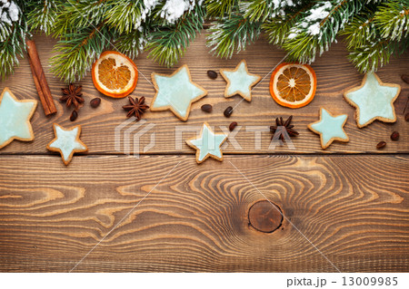 Christmas wooden background with snow fir tree, spices, gingerbr Christmas wooden background with snow fir tree, spices, gingerbr 13009985