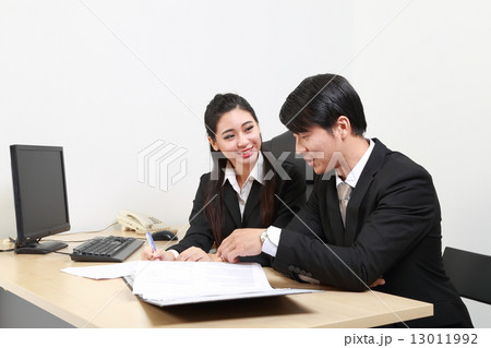 Man woman discuss document in office desk Man woman discuss document in office desk 13011992