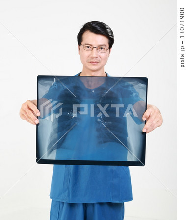 male doctor in uniform holding chest x ray in front of chest male doctor in uniform holding chest x ray in front of chest 13021900