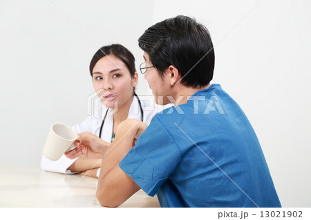 Male and female doctor in uniform take break discuss  13021902