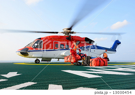 The helicopter landing officer loading baggage to helicopter at 13030454