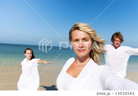 People performing yoga on the beach People performing yoga on the beach 13039563