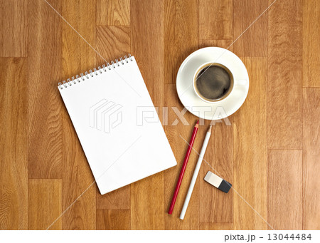 Blank notepad with office supplies and cup of coffee on wooden t Blank notepad with office supplies and cup of coffee on wooden t 13044484