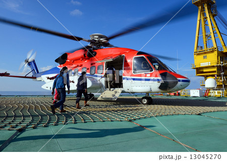 The helicopter landing officer take care passenger to embark hel The helicopter landing officer take care passenger to embark hel 13045270