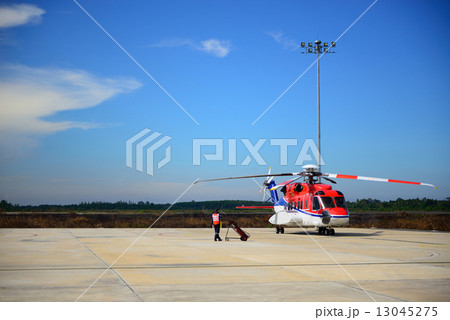 fireman is guarding for helicopter before start up engine 13045275