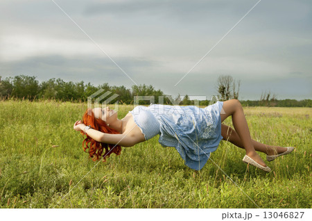 Levitating girl flying above the ground. 13046827