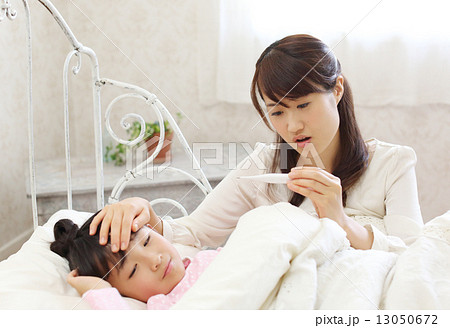 病気になった子供を看病するお母さん 13050672