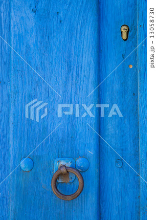 Old run-down blue painted wooden door and lock 13058730