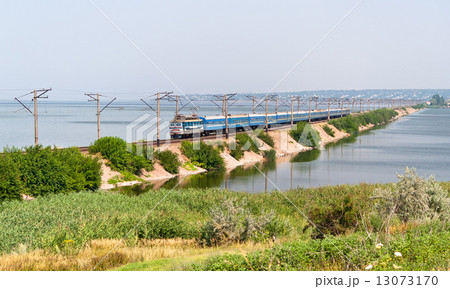 Passenger electric train on a dam 13073170