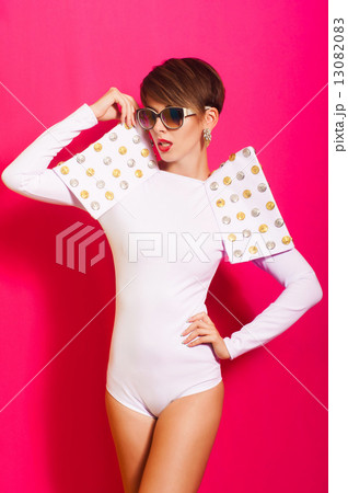 Beautiful girl in a white concert suit on pink background 13082083