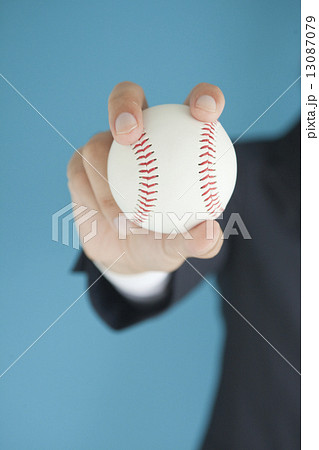 野球ボールを持つビジネスマンの手の写真素材