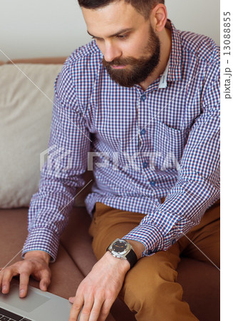 Young bearded man working on laptop Young bearded man working on laptop 13088855