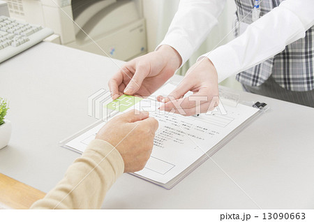 診察受付をする患者と事務員の手元 診察受付をする患者と事務員の手元 13090663