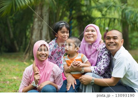 malay muslim family having fun playing in the park malay muslim family having fun playing in the park 13093190
