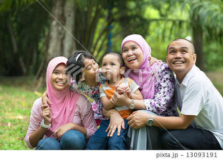 malay muslim family having fun playing in the park malay muslim family having fun playing in the park 13093191