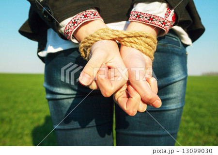 Hands tied up with rope 13099030