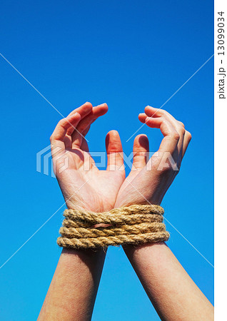 Hands tied up with rope 13099034