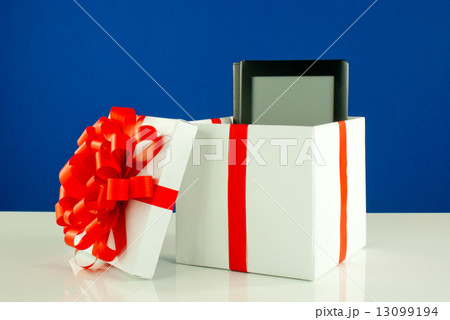 Electronic book reader in a box against blue background Electronic book reader in a box against blue background 13099194