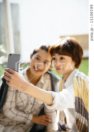 スマートフォンで自撮りする女性二人 スマートフォンで自撮りする女性二人 13106599