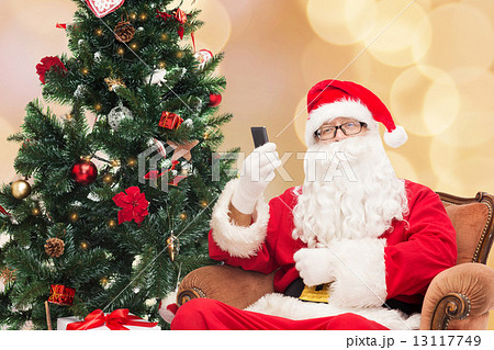 santa claus with smartphone and christmas tree 13117749