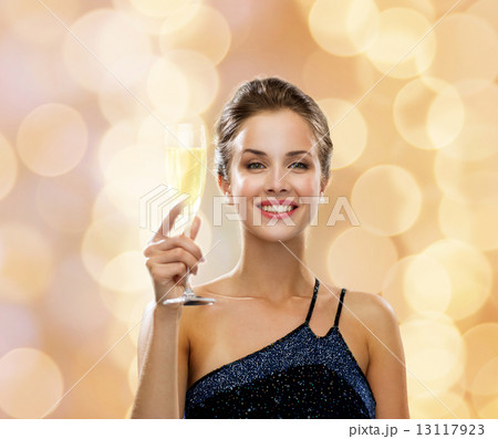 smiling woman holding glass of sparkling wine 13117923