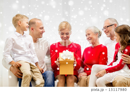smiling family with gift at home 13117980
