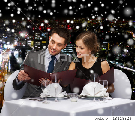 smiling couple with menus at restaurant smiling couple with menus at restaurant 13118323