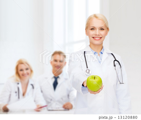 smiling female doctor with green apple 13120880