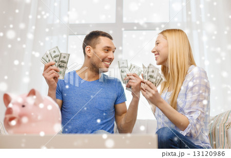 happy couple with money and piggybank at home happy couple with money and piggybank at home 13120986