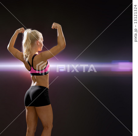 sporty woman from the back flexing her biceps 13121324