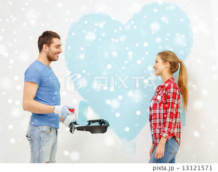 smiling couple painting big heart on wall 13121571