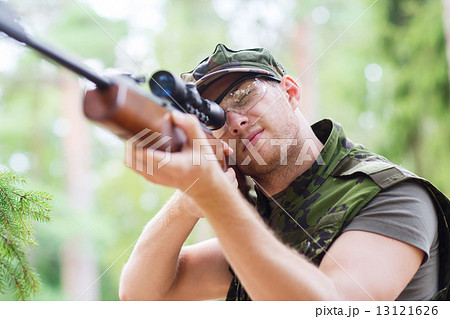 young soldier or hunter with gun in forest young soldier or hunter with gun in forest 13121626
