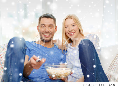 smiling couple watching tv at home smiling couple watching tv at home 13121640