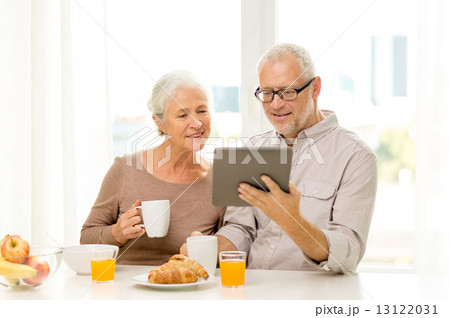 happy senior couple with tablet pc at home 13122031