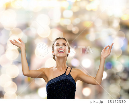 smiling woman raising hands and looking up smiling woman raising hands and looking up 13122330