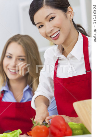 Women Friends Preparing Vegetables Salad Food in Kitchen 13123803