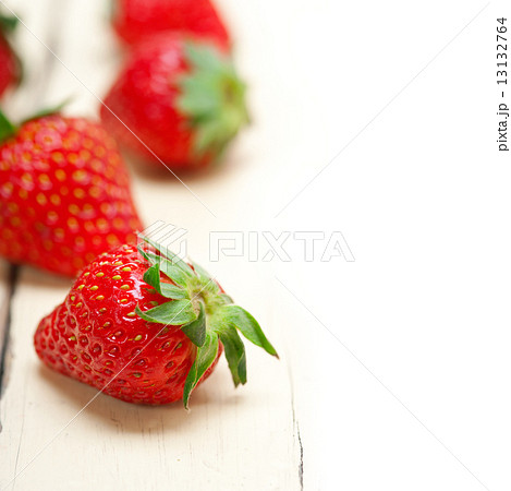 fresh organic strawberry over white wood 13132764