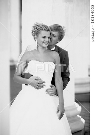 portrait of young groom hugging smiling bride from back 13134058