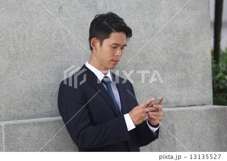 携帯をいじるアジア人男性 13135527