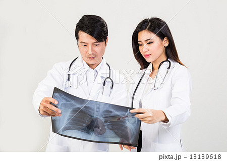 Medical doctors discussing whilst referring to X-ray film Medical doctors discussing whilst referring to X-ray film 13139618