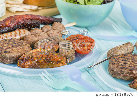 BBQ - Assorted barbequed meat and bread on a blue background.  13139976