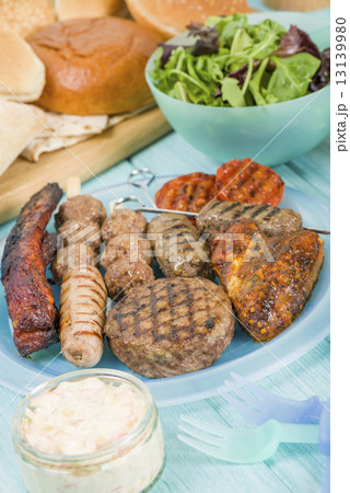 BBQ - Assorted barbequed meat and bread on a blue background.  13139980