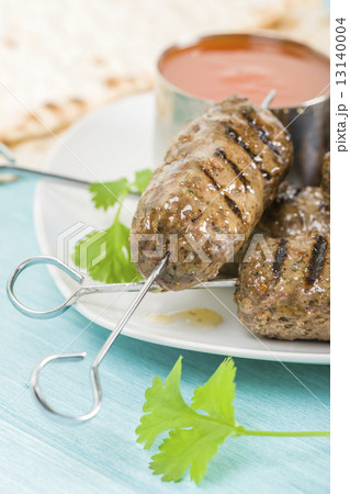 Seekh Kebab - Grilled spiced lamb mince on a metal skewers served with chili sauce and lemon wedges  Seekh Kebab - Grilled spiced lamb mince on a metal skewers served with chili sauce and lemon wedges  13140004