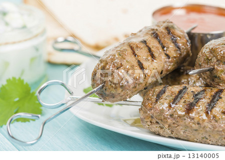Seekh Kebab - Grilled spiced lamb mince on a metal skewers served with chili sauce and lemon wedges  13140005